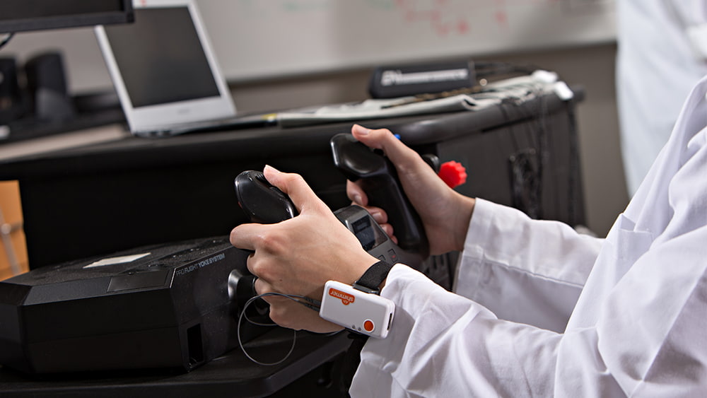 Hands on a controller in a lab. 