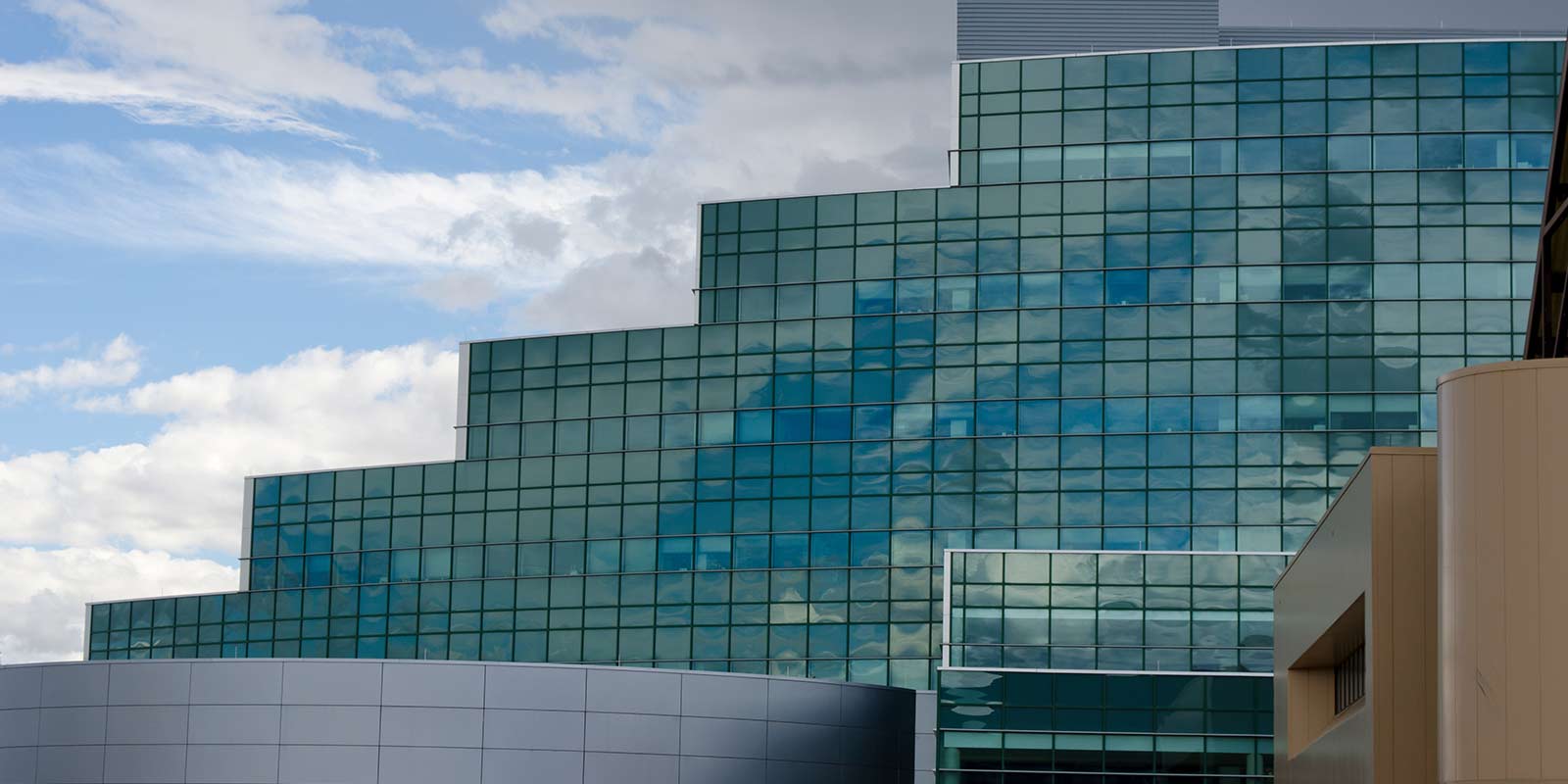 A view of the National Security Science Building at Los Alamos National Laboratory. The glass architecture of the building reflects the coming weather.